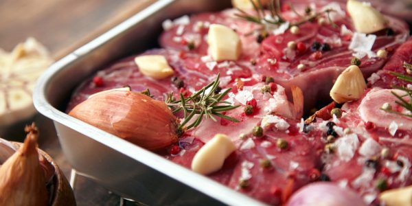 primo-piano-di-carne-in-tegame-d-acciaio-spezie-intorno-aglio-rosmarino-cipolle_346278-568
